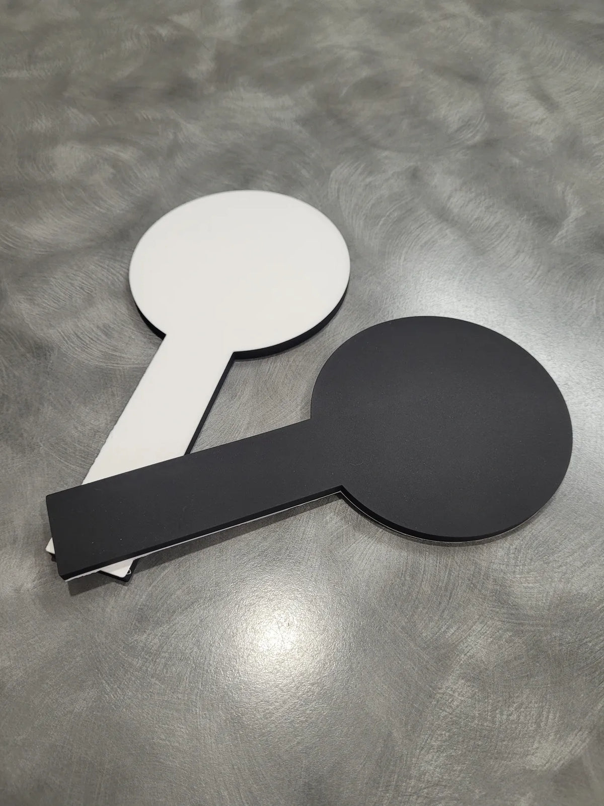two easy find coasters one white side up and one black side up. with grey background